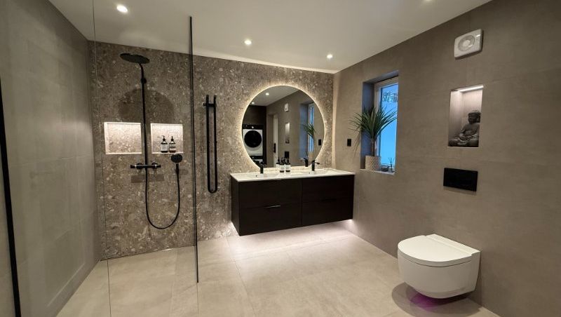 Moderne flislagt bad med, frittstående toalett, dusj og servant