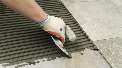 Dekorativ, hvit peis med utskjæringer montert i stue med spotbelysning.